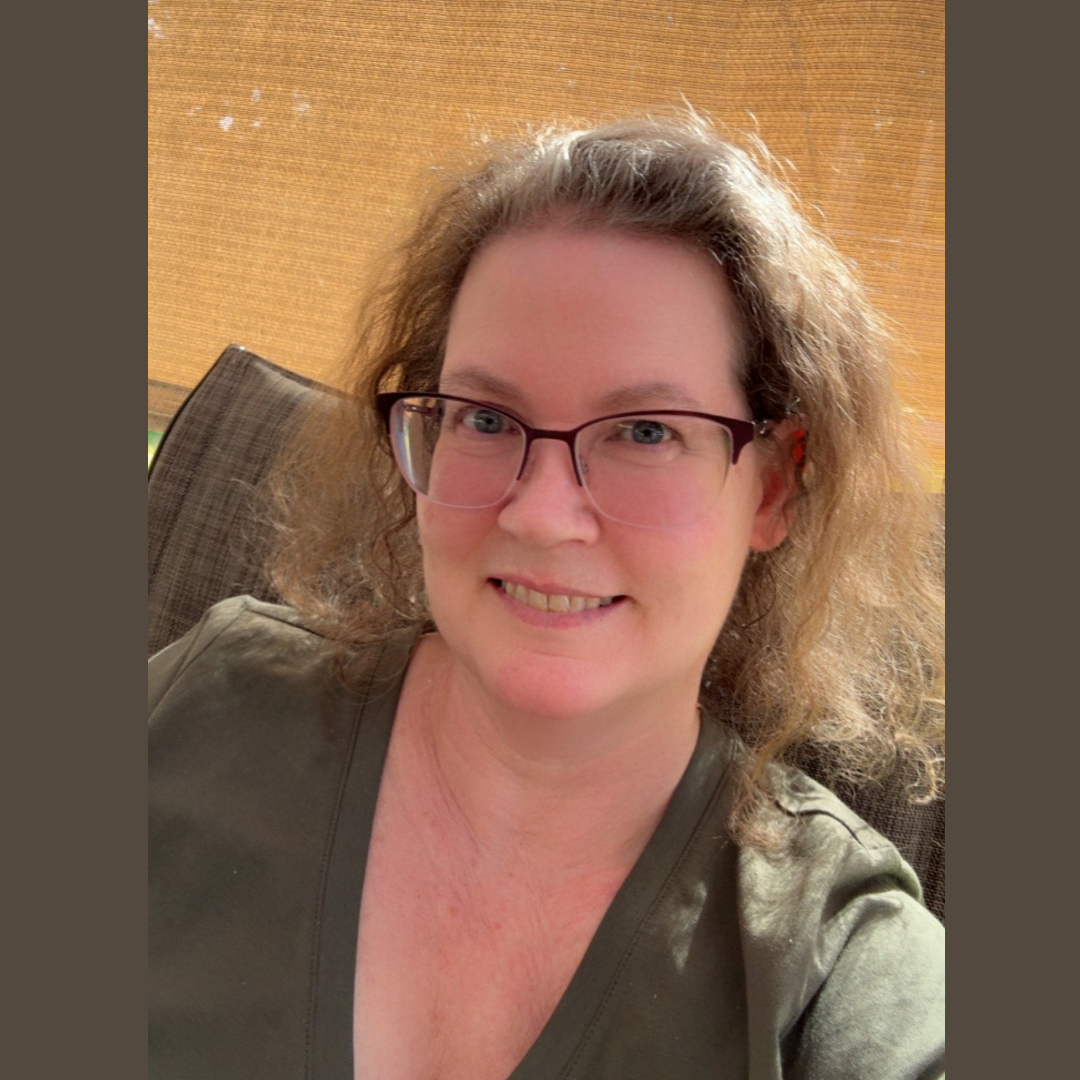 An image of the author, Tracy, sitting outside under the canopy of her pergola in the sunshine.